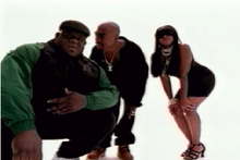 Shot from the music video, with stand-in Biggie on the left, Shakur in the middle, and Lil' Kim on the right. HitEmUpVideo.png