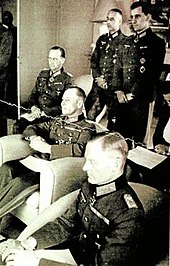 A meeting between the military resistance's inner circle and Rommel at Mareil-Marly 15 May 1944. From left, Speidel - behind, Rommel - center, Stulpnagel - front. The officer standing left is Rudolf Hartmann. The others are unknown. A meeting between the military resistance's inner circle and Rommel, Mareil-Marly, 15. May 1944.jpg