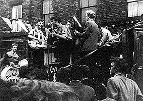 The Quarrymen performing in Rosebery Street, Liverpool on 22 June 1957[1] (Left to right: Hanton, Griffiths, Lennon, Garry, Shotton and Davis)