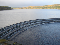 Bild eines Reservoirs mit Wasser, das auf dem Überlauf kaskadiert