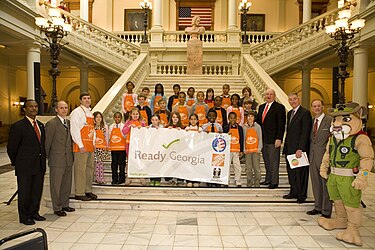 Governor Sonny Perdue, GEMA/OHS director Charley English, Ready Kids mascot Rex the mountain lion, and Georgia elementary school students pose during Ready Georgia's official launch at the state capital building. ReadyGeorgiaLaunch.jpg