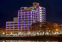A photo of a brightly and colorfully lit renovated hotel near the Rock River in Rockford, Illinois. This use to be the Ziock building