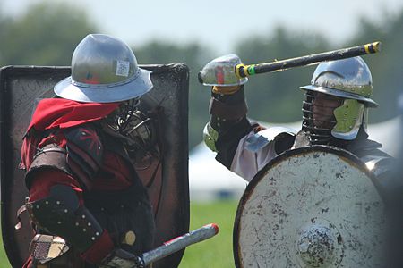 Fighters practicing at Pennsic XXXVIII (2009). Note the use of rattan swords, edge padding on the shields, and bar grills added to the helmets SCA heavy combat at Pennsic 38.jpg