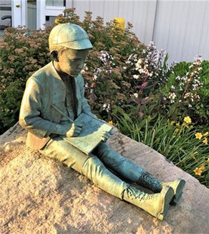 Statue of O'Neill as a boy, sitting and writing, overlooking the harbor of New London, Connecticut