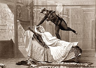 man dressed as a giant fly hovering over a reclining young woman