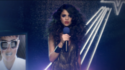 Gomez in the music video, singing at a Japanese karaoke bar, while the karaoke machine projects her as Max Headroom. Love You Like A Love Song Screenshot.png