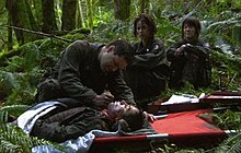 Chief Tyrol (Aaron Douglas) euthanizes Socinus (Alonso Oyarzun) as Seelix (Jennifer Halley) and Cally (Nicki Clyne) look on. This scene was controversial during production. Douglas described filming such scenes as "very draining" emotionally. BattlestarGalactica -- 2x02 - Valley of Darkness.jpg