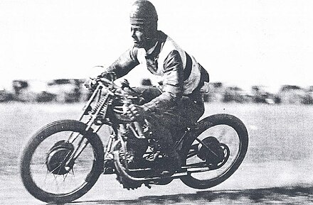 Col Stewart races his speedway motorcycle wearing a leather helmet. Photo taken around 1930.