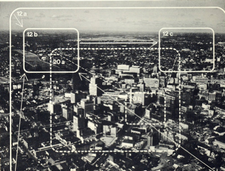 Photograph of downtown Rochester shows two of the scene plots used in the film: a zoom to horizon and pan across, and a street-corner zoom from medium close-up. Verticals, diagonal pans, up-zooms and other combinations were used to abstract several scenes from a few 4X5 color transparencies taken by aerial photographer---effectively simulating smooth helicopter and aircraft cinematography at a fraction of the cost. Photoanlandscape.png