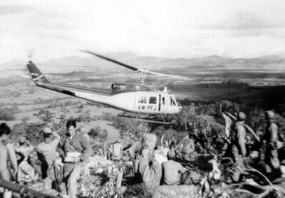 Air America Bell 205 helicopter leaving a Hmong fire support base in the Laotian Plain of Jars, c. 1969