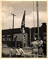 Military personnel raise the E Award flag at the Lincoln headquarters. Army-Navy-E2.jpg