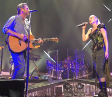 A color picture of singer Gwen Stefani and Blake Shelton performing their song 