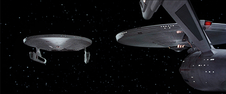 The Enterprise (right) in Star Trek II: The Wrath of Khan (1982). Though the vessel was heavily redesigned for film from the television model, it retains the same basic modules. In designing the Reliant (left), Joe Jennings and Mike Minor rearranged those components, such as attaching the engine nacelles directly below the saucer section, to establish its connection to the Star Trek universe while distinguishing it from the Enterprise.[67]