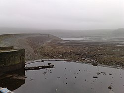 Bild eines fast trockenen Reservoirs im schweren Nebel