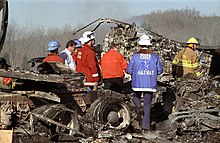 Investigators examine the remains of a tractor-trailer involved in the accident 1990 I-75 fog accident semi truck.jpg