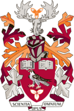 Escudo de armas de Mohawk College con colores principalmente burdeos, carmesí y naranja.