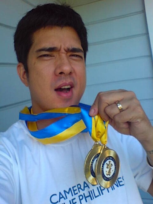 Magalona holds up two medals awarded by the Camera Club of the Philippines