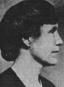 A white woman's face, in profile, facing viewer's right. Her hair is pinned up.