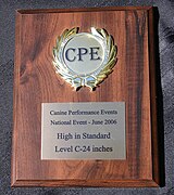 An award plaque made of wood with a printed metal plate and a medallion