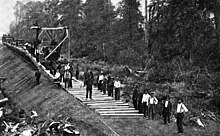 Laying railroad track "in the woods". Photo published in Railway and locomotive engineering: a practical journal of motive power, rolling stock and appliances, Volume 15, 1902 Tracklayingcrewinwoods.jpg