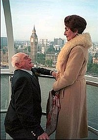 Jim proposes to Dot, 21 December 2001. The scenes were filmed on-location in one of the carriages on the Millennium Eye in central London away from the soap's typical set. The coat worn by Dot here was given to her in the soap by Angie Watts in the 1980s, and Brown has suggested that it's a rarely used part of her costume which only appears on very special occasions. Dot&jim0.jpg