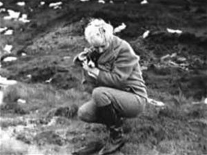 In this photograph taken by Brady in November 1963, Hindley crouches over John Kilbride's grave on Saddleworth Moor with her dog, Puppet.