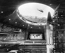 Blofeld's SPECTRE volcano base complete with spacecraft-swallowing Bird One spacecraft, helipad and attack helicopter, and command centre in the 1967 film You Only Live Twice. The world map in the background is common to emphasise the aim of world domination. SPECTRE.jpg