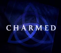 A dark blue triquetra over a darker blue background that fades to black near the edges with the word charmed in capital letters across the center using a light-green, medium-sized font
