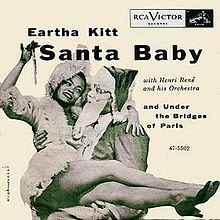 Singer Eartha Kitt sits on Santa Claus's lap in a sepia-toned photograph.