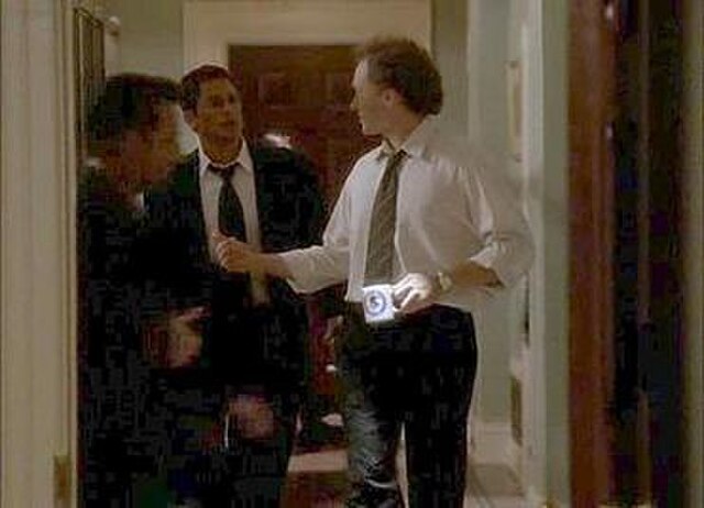 Sam Seaborn and Josh Lyman converse in the hallway in one of The West Wing's noted tracking shots.