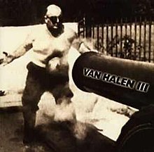 A black-and-white photograph of a man being shot in the stomach with a cannonball. The cannon reads "Van Halen III"