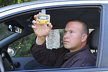 A driver hangs his in-vehicle parking meter in the window for enforcement officers to see.