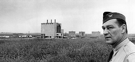 Colonel Charles E. Lancaster, base commander, is shown looking at the heating plant and POL tank farm, some of the few above ground structures built on the cancelled Bong Air Force Base. The project was cancelled a week after this photo was taken.