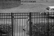 The person of interest who parked Kesse's car was captured by a surveillance camera that snapped a photo once every three seconds. To the dismay of investigators, all three captures of the subject in frame had the suspect's face obscured by the fencing. Kesse POI.jpg