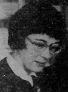 Eine weiße Frau mit kurzen Haaren und Brille, die nach unten schaut; aus einer Zeitung von 1963.