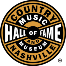 The logo of the Country Music Hall of Fame and Museum. It is features black and yellow stripes with a circular design.