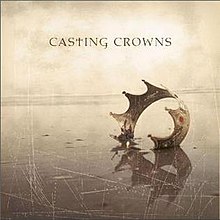 Sur un écran bronzé et rayé, une seule couronne est enfoncée dans le sol.  Au-dessus se trouvent les mots « Casting Crowns », avec le « t » minuscule remplacé par une croix chrétienne.