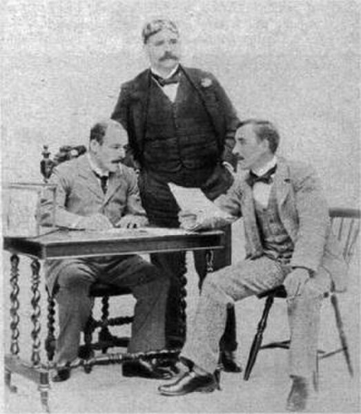 Hall (seated left) with George Edwardes (c) and Sidney Jones