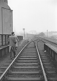 The closed high level line along a high wall to Paisley East is on the right, low level to the goods yard on the left Seedhillbridge.jpg