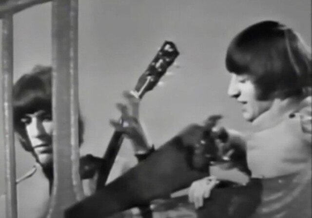 Ringo Starr (right) sawing though the studio scenery in one of the promo clips for the song