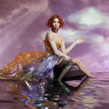 Album cover, depicting Sophie wearing a dress and sitting on a platform in a purple pool of water, in a hazy backdrop with a purple sky. Her dress seems to be made of coloured plastic, a bronze or brass looking choker is around her neck, and one of her legs is covered with a green legging.