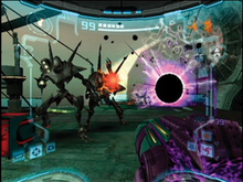 View of a futuristic looking room; mantis-like enemies on powered armor - one firing a red beam - approach the player, whose weapon (a large cannon) is visible in the corner of the screen. Something resembling a black hole is seen on the right side of the enemies, while a gray and red metallic crate is to their left. The image is a simulation of the heads-up display of a combat suit's helmet, with a crosshair surrounding the enemy and two-dimensional icons relaying game information around the edge of the frame.