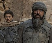 Fremen Chani (Zendaya) and Stilgar (Javier Bardem) wearing stillsuits in Dune (2021) Fremen (Chani and Stilgar) in stillsuits-Dune (2021).jpg