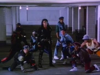 Jackson and background dancers in the "Bad" music video. Wearing clothing with a noticeable amount of buckles, Jackson showcased his "street-tough and