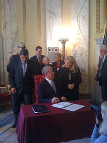 Governor Carcieri signs into law the bill which outlaws prostitution, as Rep. Joanne Giannini looks on Riprostitutionlawsign.jpg