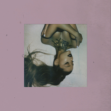 A portrait of Ariana Grande, shown upside down. A tattoo that spells out the album name can be seen below her neck. Wearing black lipstick and a ponytail, she is closing her eyes and touching both of her shoulders. The image border is colored purple, with low saturation.