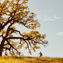 The cover depicts Bassett under a yellow tree, surrounded by a yellow grass field