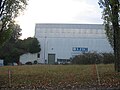 A large experimental hall at the Intersecting Storage Rings particle accelerator at CERN. The accelerator is beneath the hill that can be seen connecting to the building on the left side. The building itself is now used as part of the magnet-fabrication process for the Large Hadron Collider.