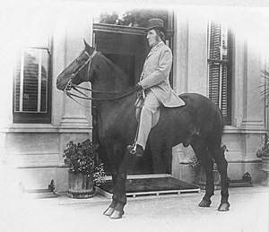 Black and white photograph of Sidney Hill riding his horse in front of Langford House