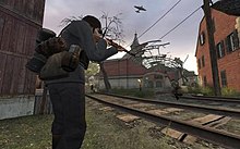 A German rifleman takes aim. The destroyed train station in the background forms one of the game's strategic points. Argentan (DoDS).jpg